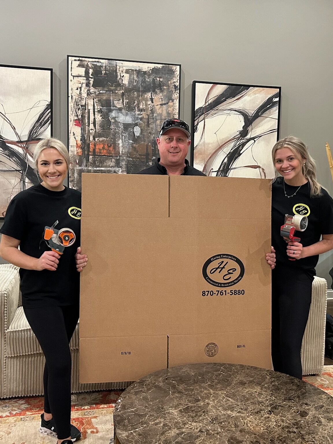 Movers holding a moving box.
